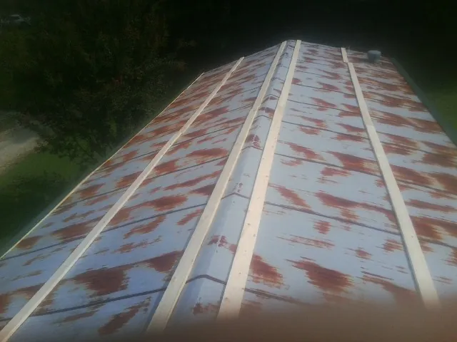 Rusted metal roof panels with new wood purlins before replacement — Storm Damage Roof Repair in Fort Campbell by Roofing Brothers