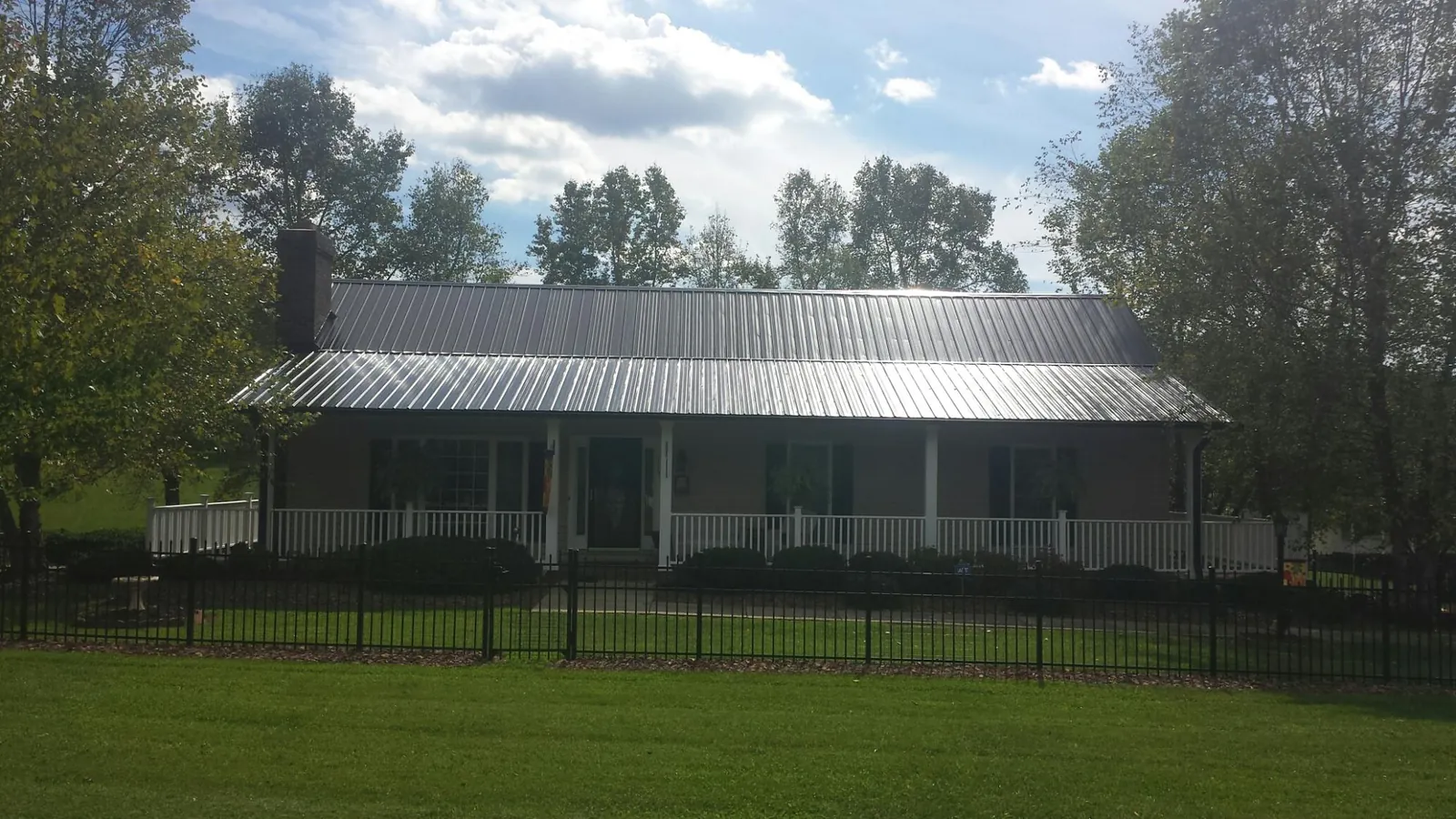 Gray metal roof on a brick ranch with a full width front porch — Gutter Guard Installation work by our crew in Fort Campbell