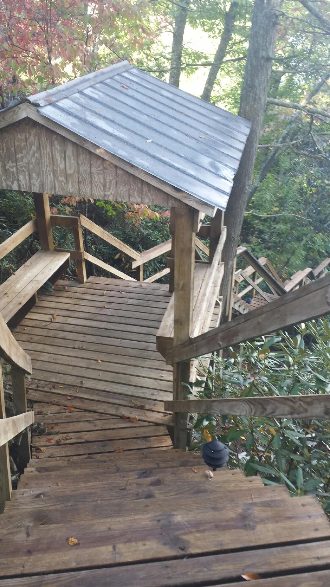 Metal roofed shelter over wooden steps on a wooded walkway — Skylight Repair & Installation work by our crew in Fort Campbell