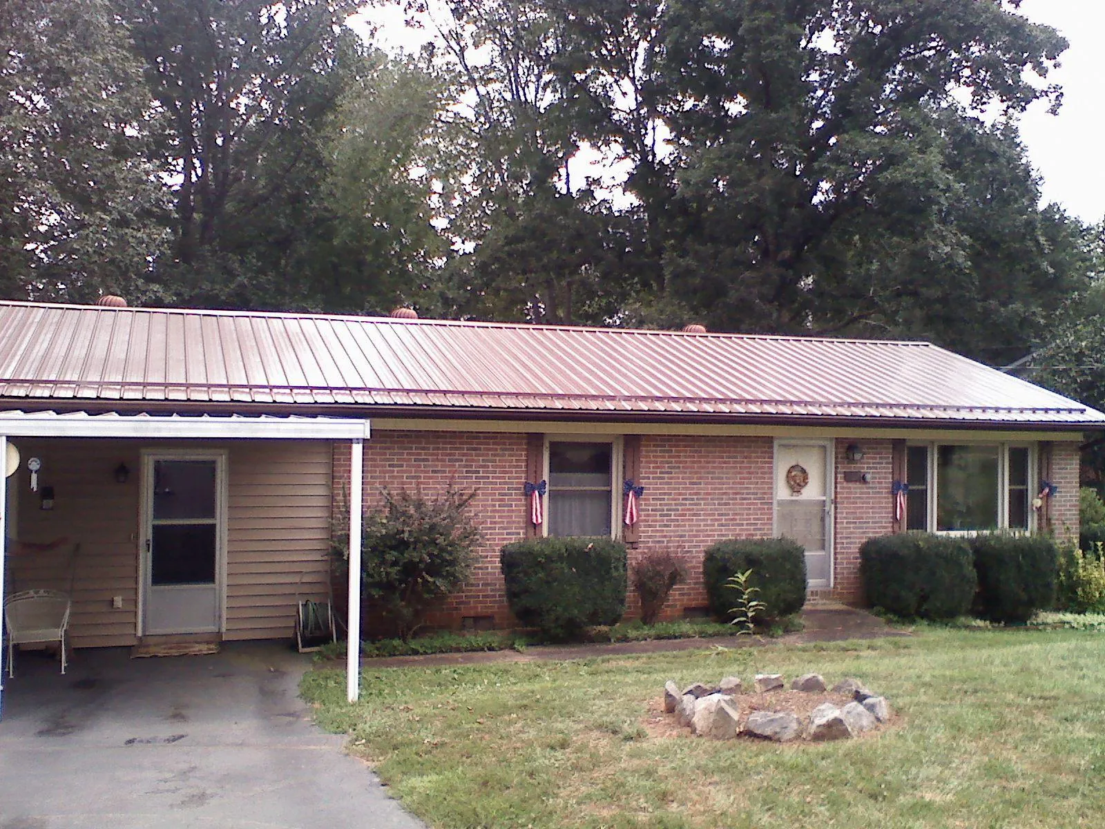 Bronze metal roof and carport on a brick ranch home — Roof Repair work by our crew in Fort Campbell