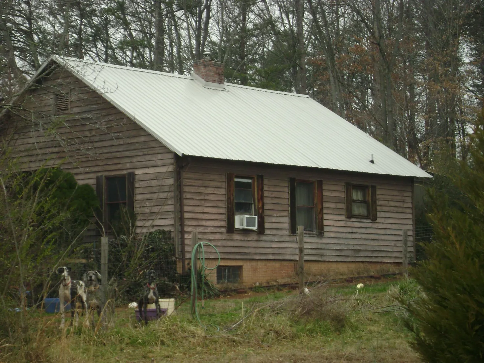 White metal roof on an old wood sided farmhouse, from a Metal Roof Installation job in Fort Campbell